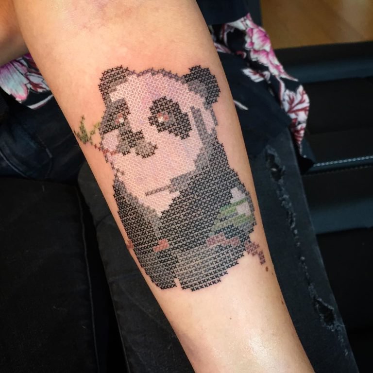 Panda tattoo eating bamboo, with cross stitch embroidery effect