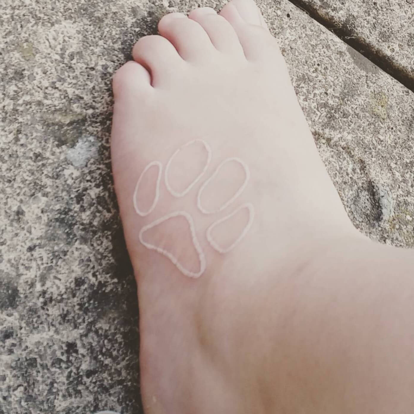 Dog footprint tattoo with white ink