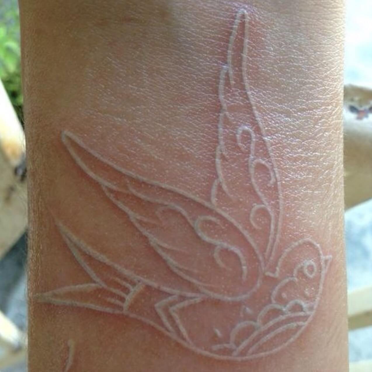 Bird tattoo made with white ink