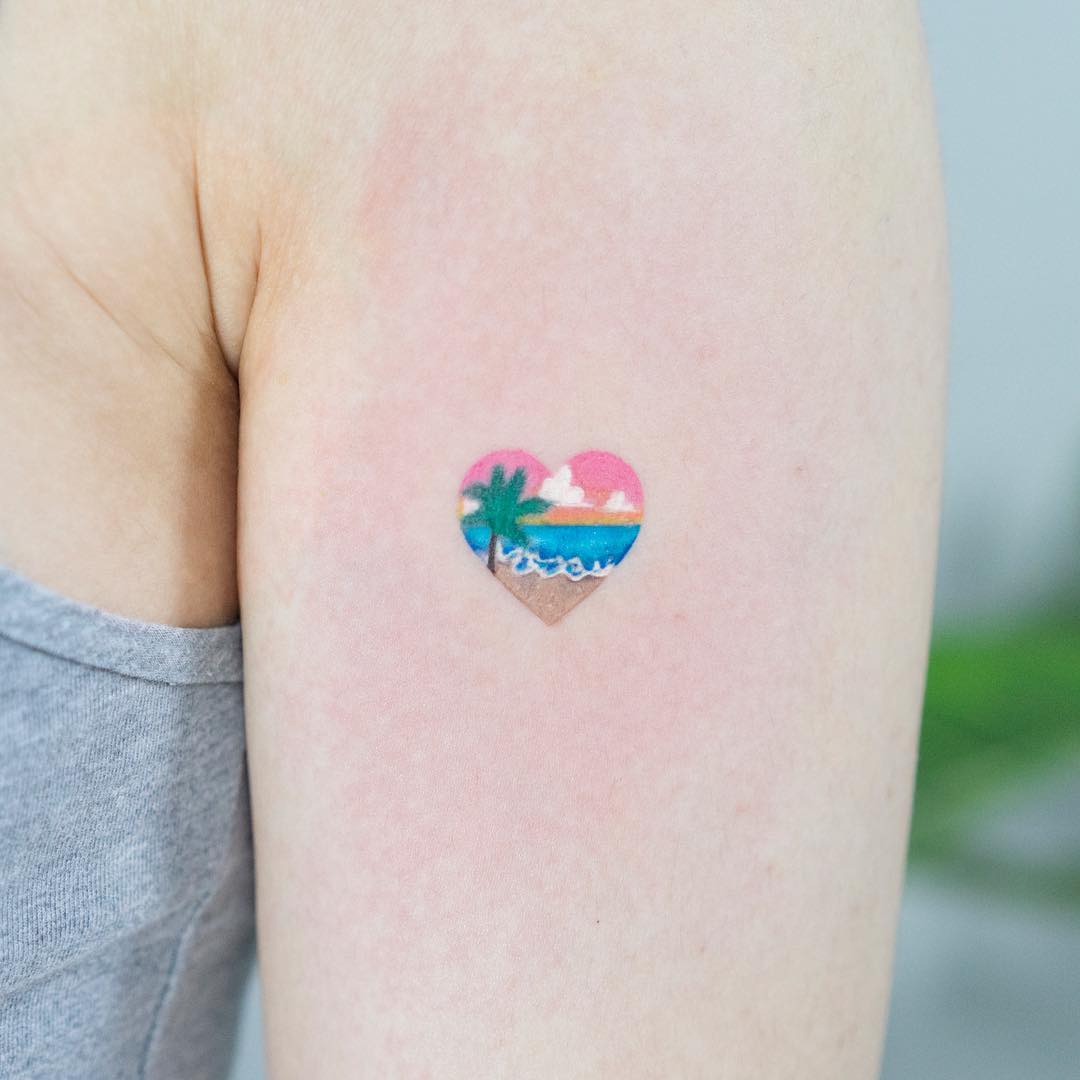 Girl with a tattoo of a heart that has a beach inside