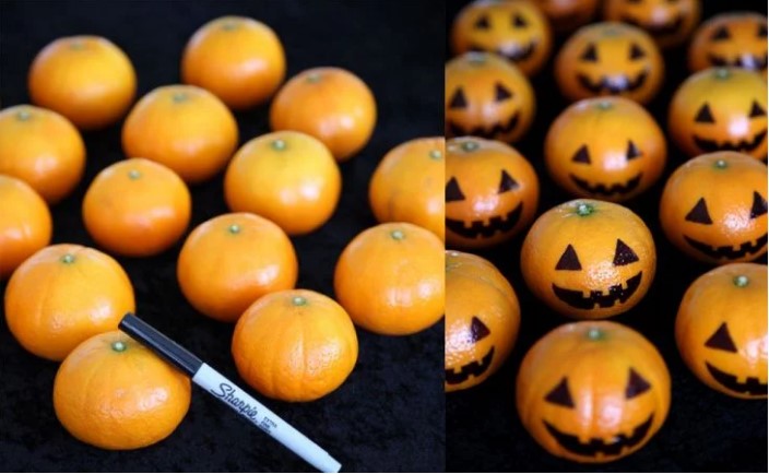 Tangerines decorated as pumpkins.
