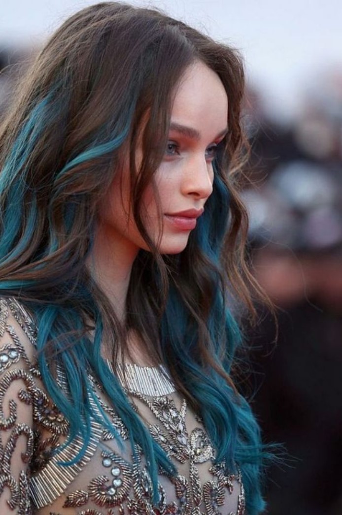 Girl in profile, showing her long hair in shades of chestnut and aqua blue