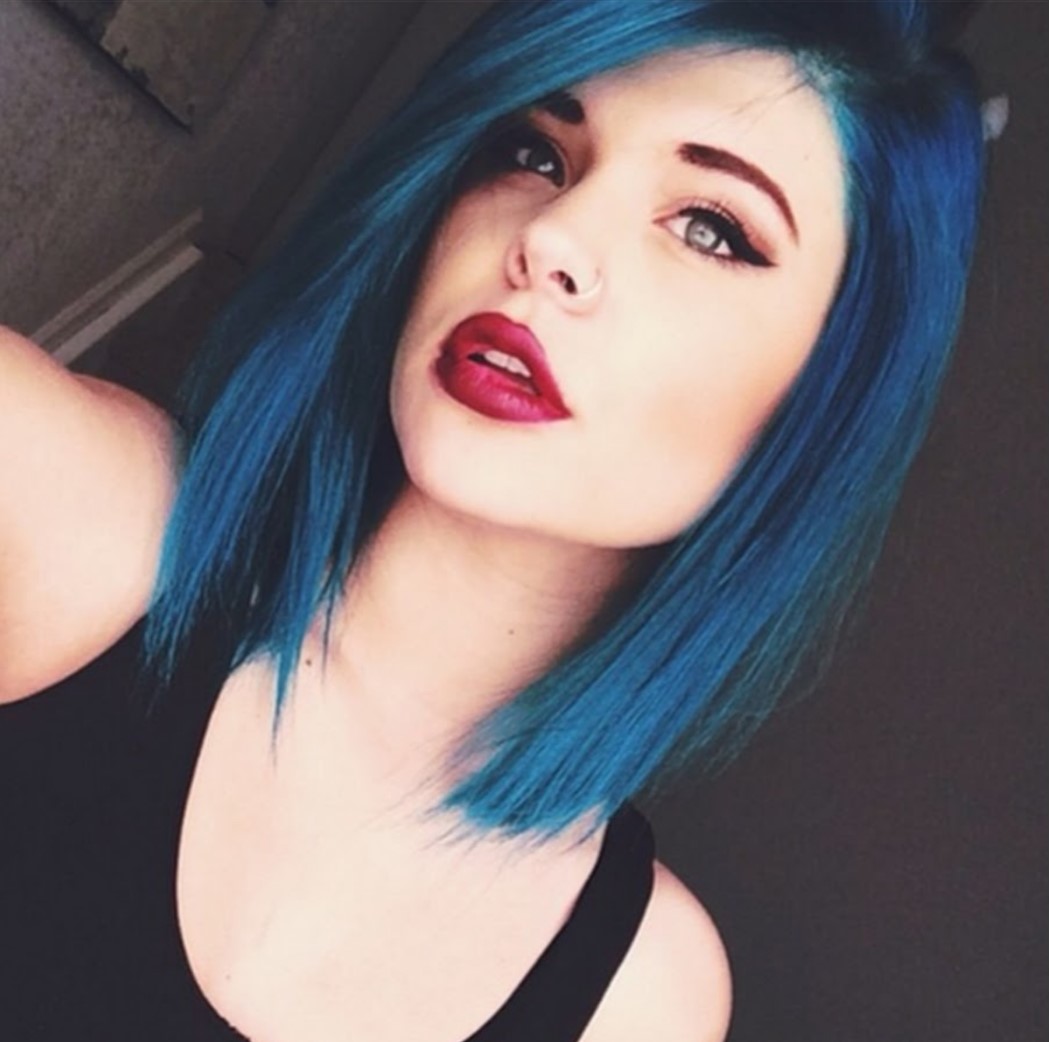 Girl taking a selfie to show her short hair in electric blue