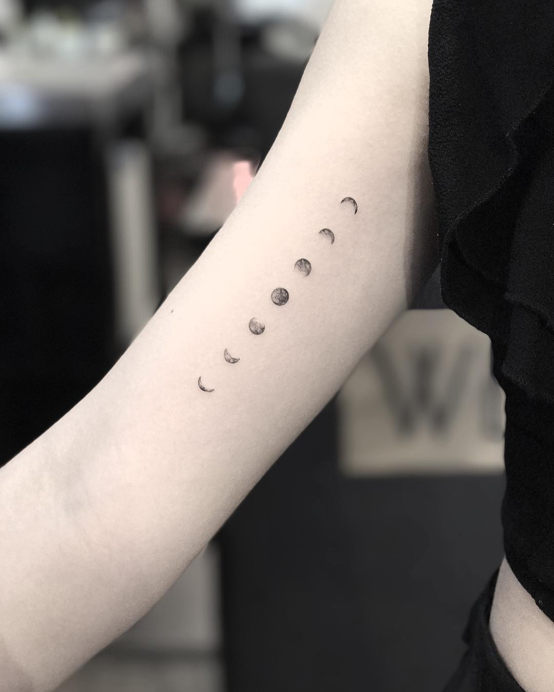Girl with a tattoo of the transition of the moons